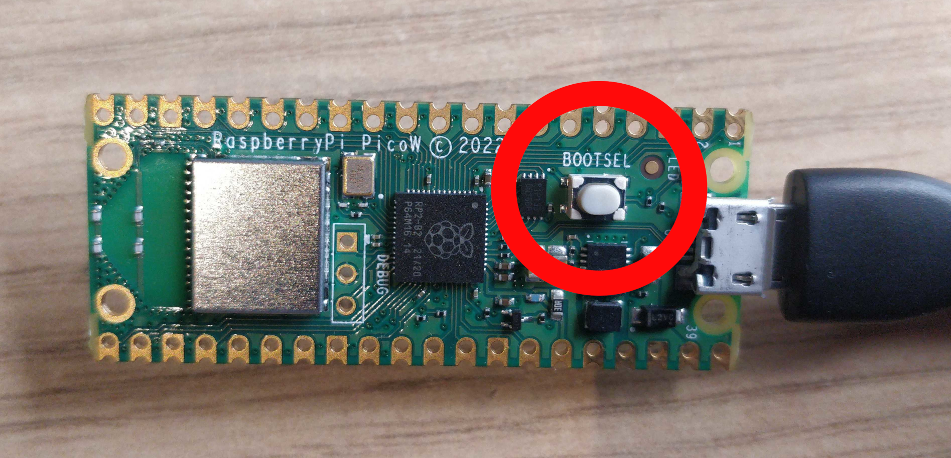 A photo of a Pico W, with a red circle around the BOOTSEL button.